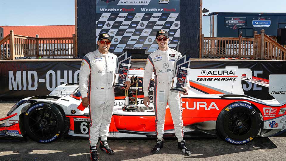 Montoya and Cameron in front of the No. 6 Acura ARX-05 at the Mid-Ohio Sports Car Course Victory Lane